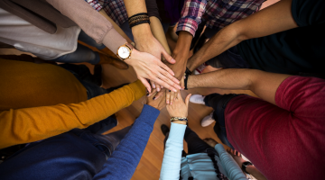 group of people with hands in center